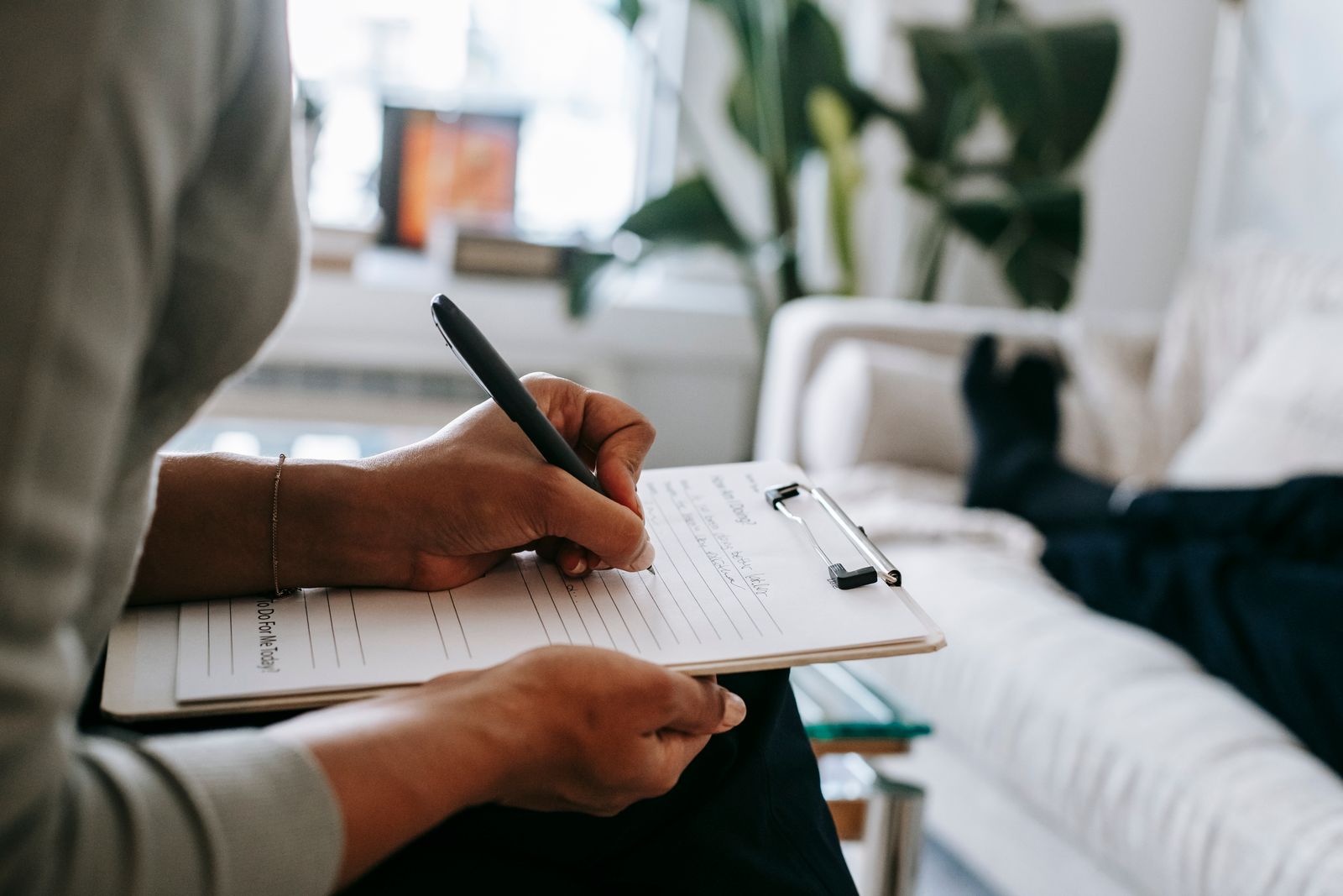 Taking notes on a clipboard during a one-on-one consultation